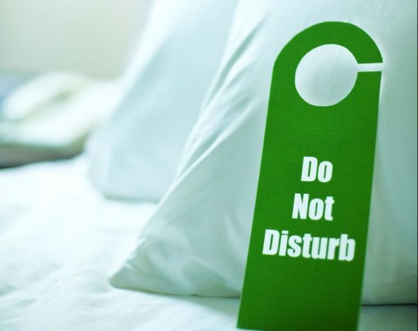 Do Not Disturb Sign on a Bed --- Image by © Tim Pannell/Corbis